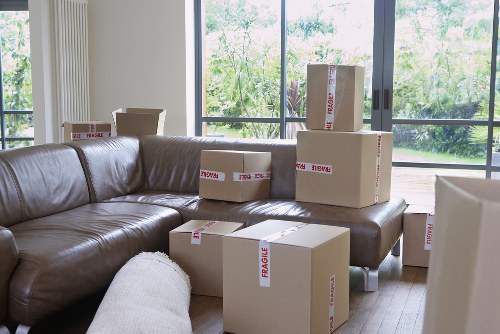 Specialist movers handling a piano through a narrow Barnes property entrance